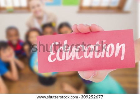 The word education and hand showing card against cute pupils and teacher in classroom with globe