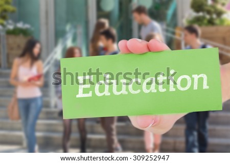 The word education and hand showing card against happy students walking and chatting outside