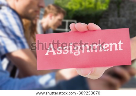 The word assignment and hand showing card against happy students sitting in a row texting