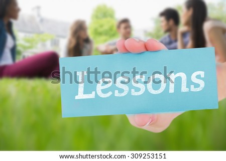 The word lessons and hand showing card against happy students sitting outside on campus