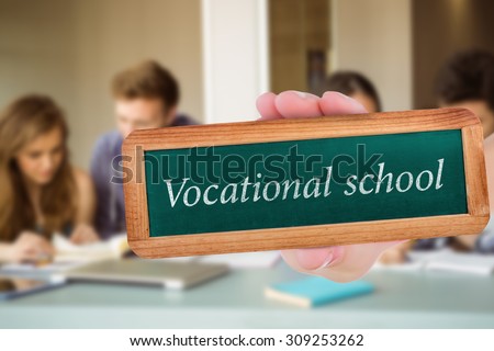 The word vocational school and hand showing chalkboard against smiling friends students revising together