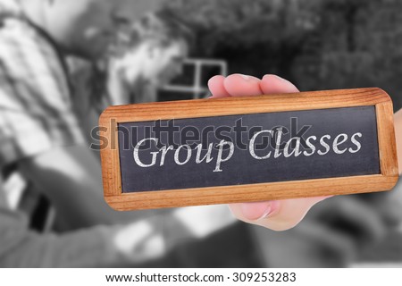 The word group classes and hand showing chalkboard against happy students sitting in a row texting