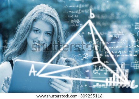 Maths equations against pretty student smiling at camera using tablet pc