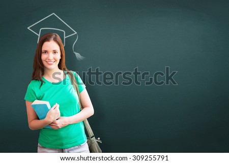 Student smiling at camera in library against teal