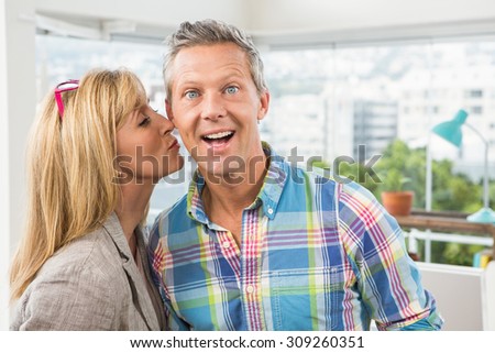 Portrait of casual designer giving her colleague kiss on cheek in the office