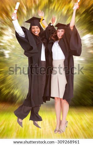 Full length of two women celebrating in the air against trees and meadow in the park