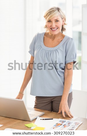 Portrait of a smiling designer working on a photo catalog at office