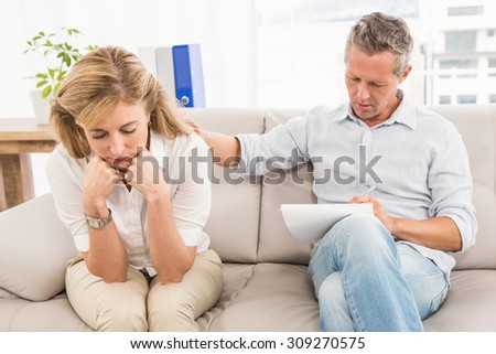 Concerned therapist comforting female patient in the office