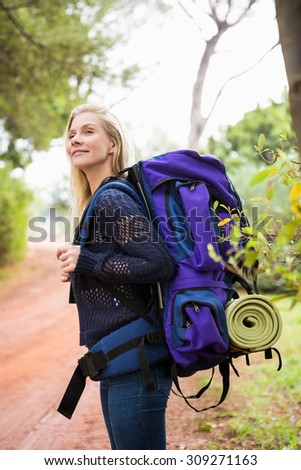 Side view of a female hiker waiting by the side of the road