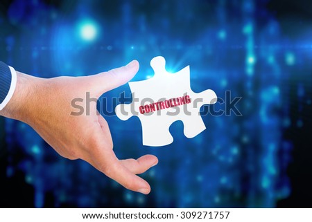 The word controlling and businessman pointing with his finger against digitally generated black and blue matrix