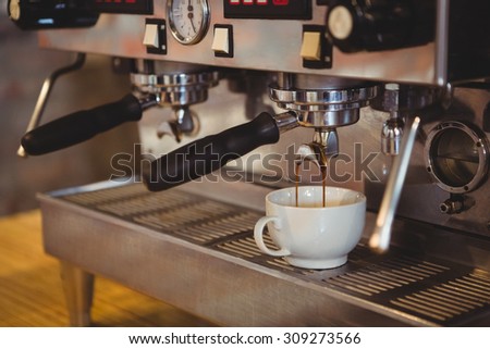 Machine making a cup of coffee in a cafe