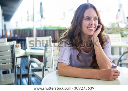 Pretty woman sitting outside at cafe on a sunny day
