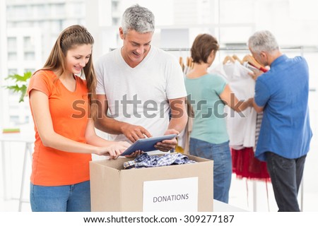 Smiling casual business people sorting donations in the office