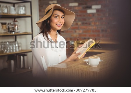 Beautiful businesswoman reading a book outside at the coffee shop
