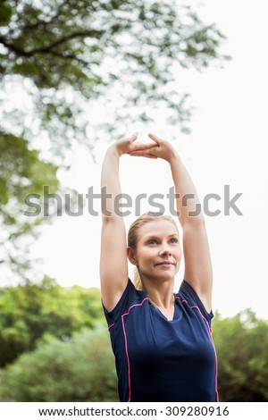 Serious athletic woman doing arms stretching