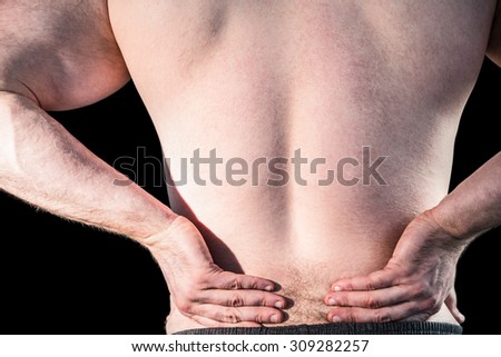 Strong bodybuilder with painful back on black background