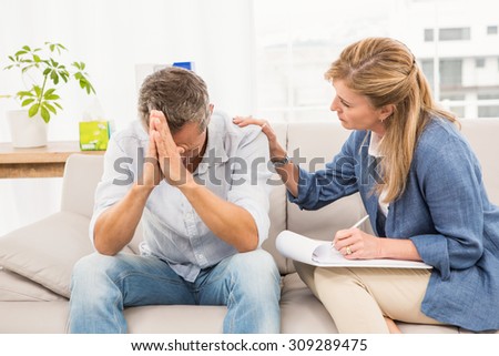 Concerned therapist comforting male patient in the office