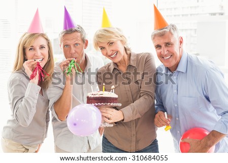 Portrait of happy casual business people celebrating birthday in the office