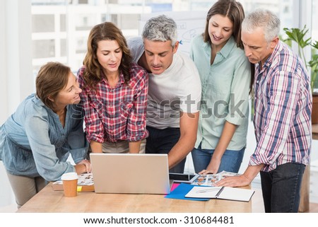 Casual business team having a meeting using laptop in the office