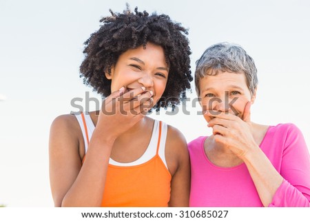 Portrait of two sporty women laughing to camera at promenade