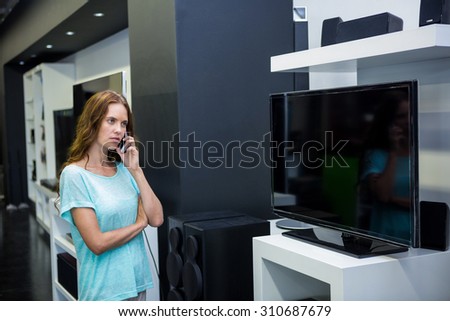 Pretty woman shopping for new television at the electronics store