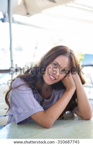 Pretty woman sitting outside at cafe on a sunny day