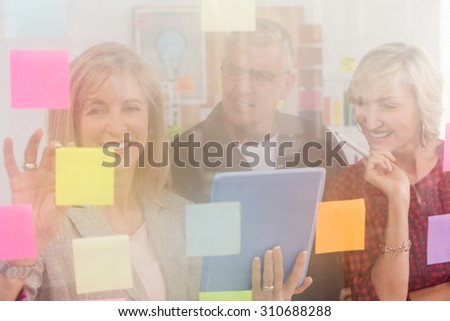 Business team working on tablet and sticky post its at office