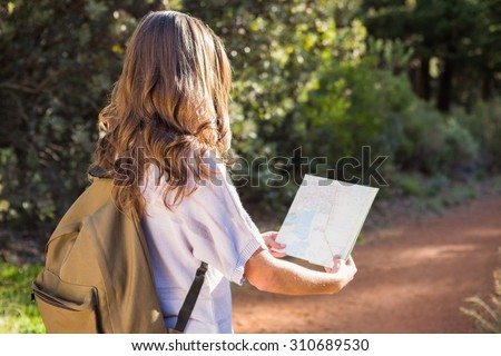 Brunette hiker reading map in the nature