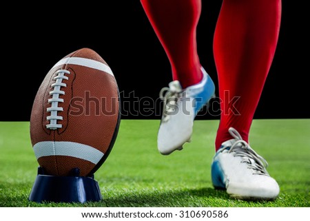 American football player being about to kick football on american football field