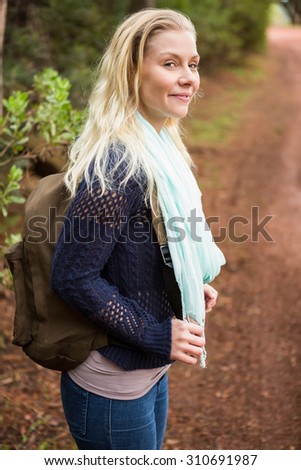 Profile view of a female hiker waiting by the side of the road