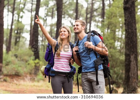 Young happy hiker couple pointing in the distance in the nature