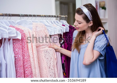 Brunette woman shopping for clothes in fashion boutique