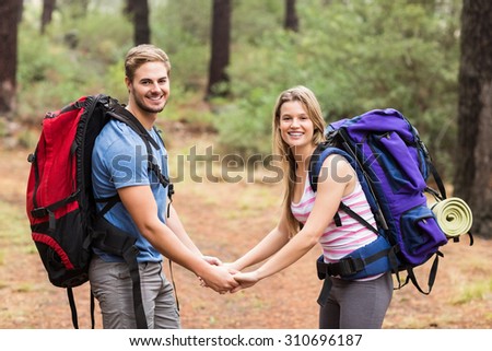 Young happy hiker couple holding hands in the nature
