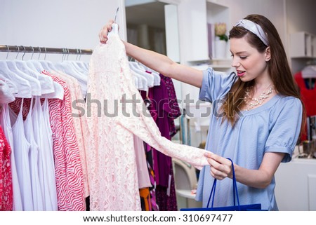 Brunette woman shopping for clothes in fashion boutique