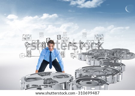 Focused businessman lifting up something heavy against blue sky