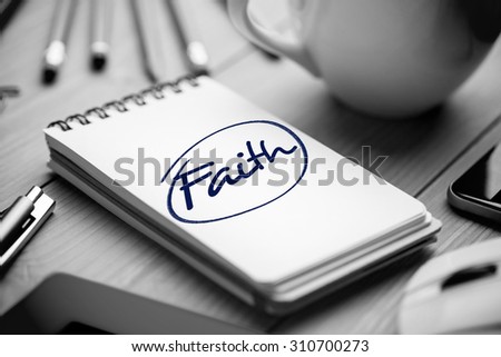 The word faith against notepad on desk