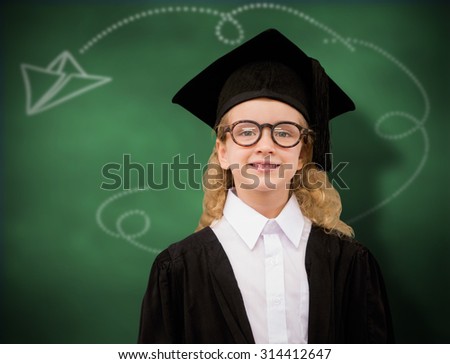 Cute pupil in graduation robe against green chalkboard