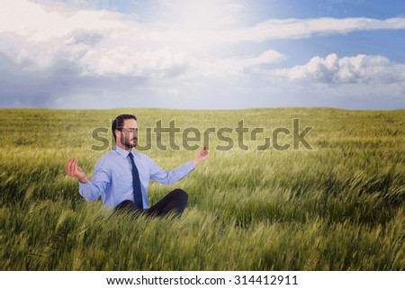 Businessman in suit sitting in lotus pose against nature scene