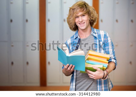 Student reading book against closed lockers in a row at the college