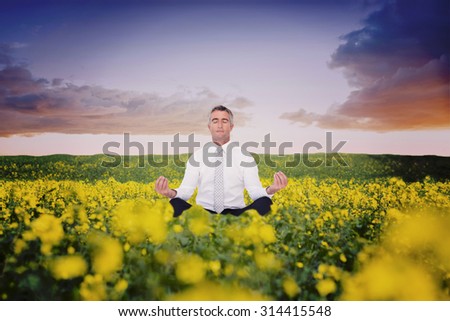 Zen businessman meditating in lotus pose against nature scene