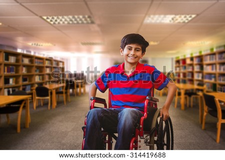 Boy sitting in wheelchair in school corridor against view of library