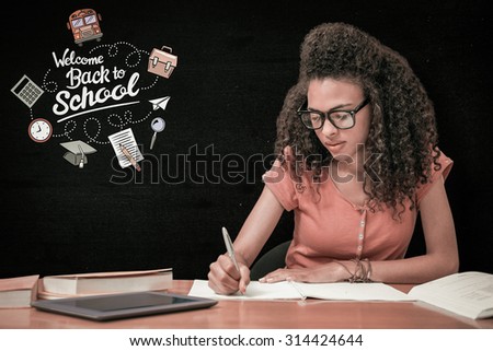 Student sitting in library writing against black