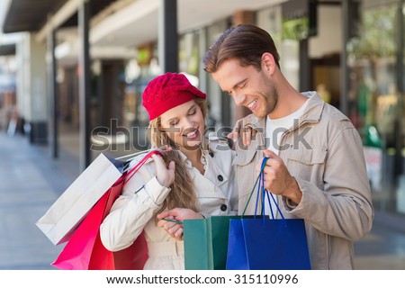 A happy couple looking inside a bag at the mall