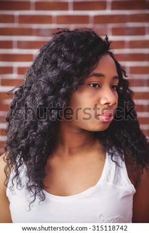 Young woman posing looking to side on red brick background