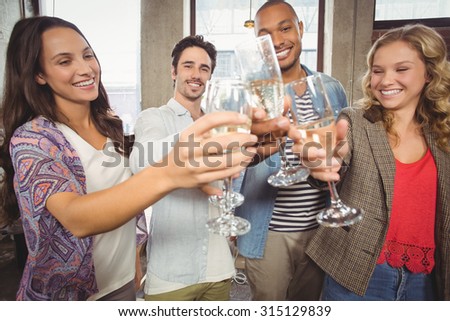 Colleagues toasting with champagne in creative office