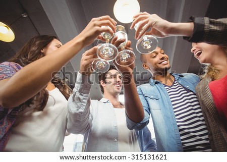 Low angle view of happy colleagues toasting with champagne in creative office