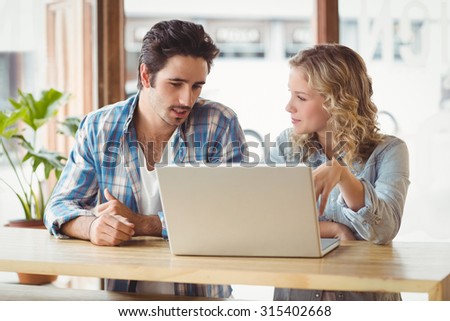Creative business people looking at laptop while sitting in office