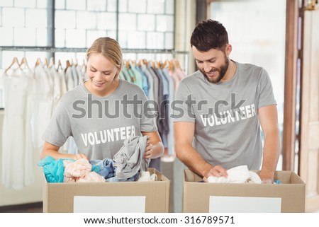 Volunteers separating donations clothes in office