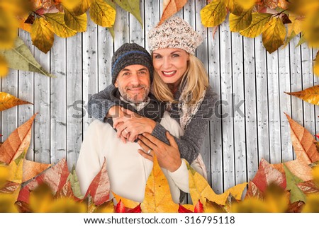 Portrait of wife embracing husband against digitally generated grey wooden planks