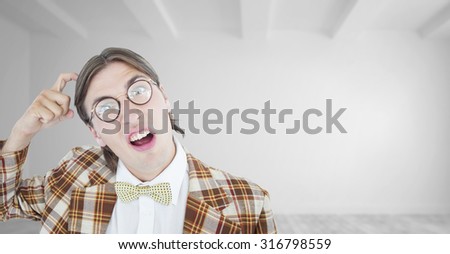 Geeky hipster scratching his head against bright white room